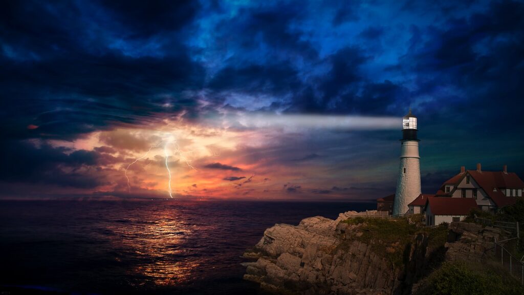 picture of a lighthouse brightening a dark, stormy sky