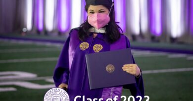 Asian-Hispanic looking woman who is in a purple graduation gown, black cap, and hot pink N95 mask. She stands with a purple diploma in one hand and a cane in the other. The background is a grassy football field and purple and white curtains. Caption says, "Class of 2023" with a purple and white seal on the bottom of the picture.